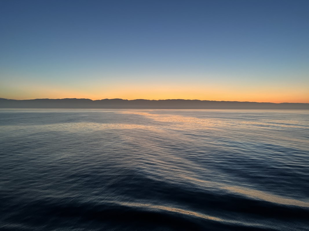 View of an Alaskan shoreline during sunrise on a cruise ship.