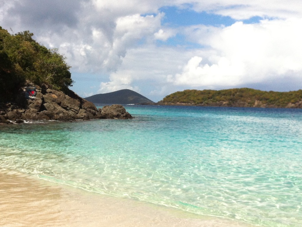 View of a beautiful sandy beach, with crystal clear waters and spectacular coastal rock formations.